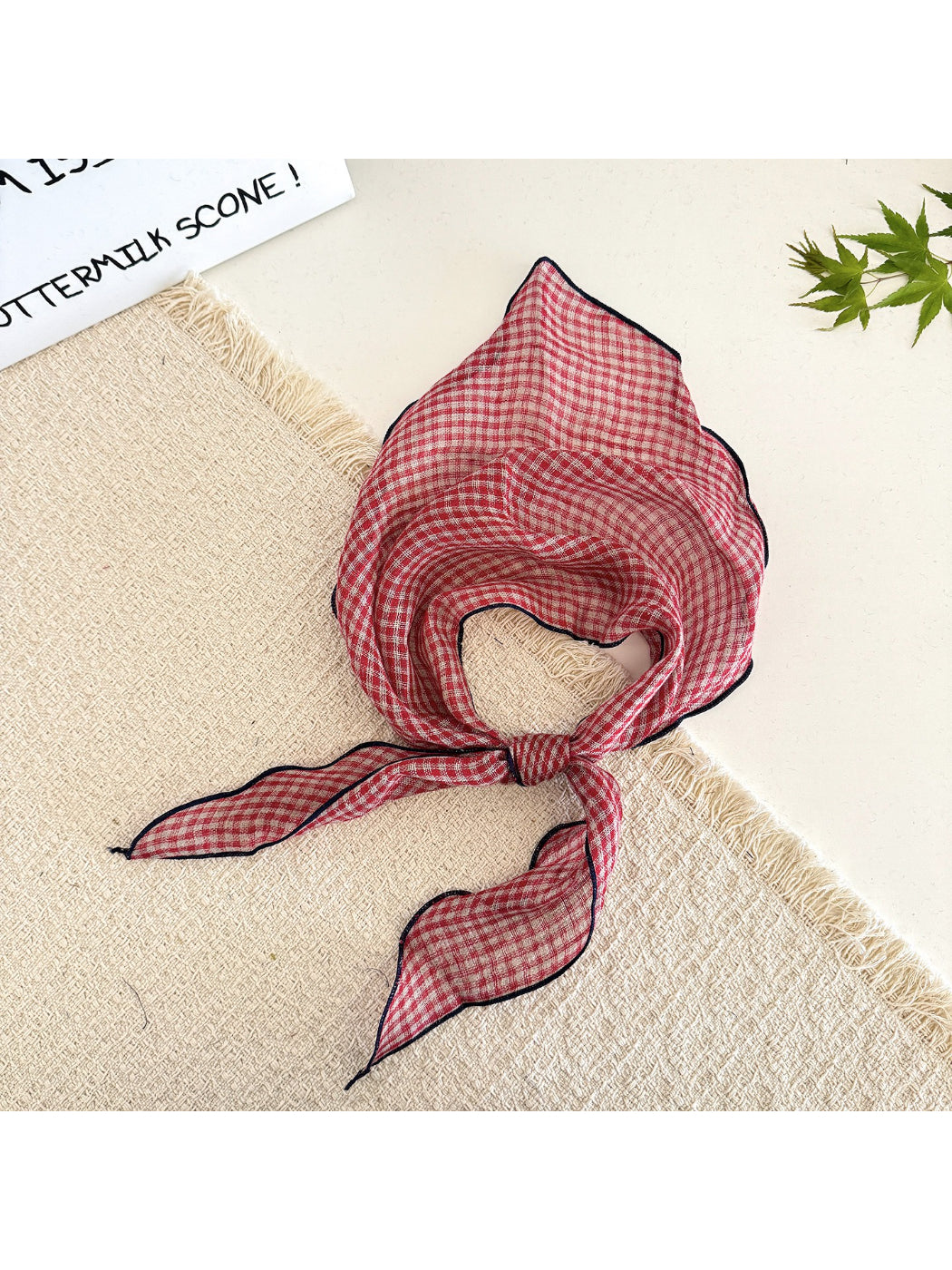 Model with classic check tie head scarf tied under the chin