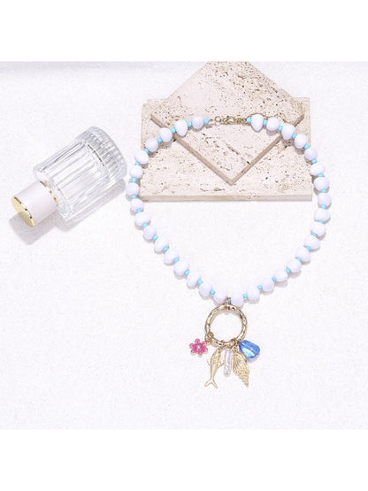 Neckit beaded necklace with ring charm displayed on a flat surface with soft lighting