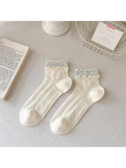 Rufia Sweet Frill Edge Ribbed Socks in pastel blue displayed on wooden surface
