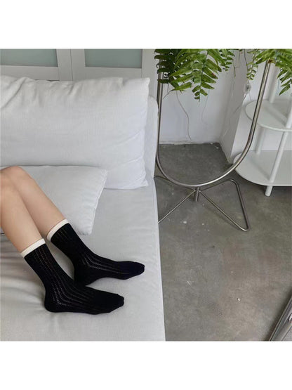 Side view of Rufia mesh color block mid-calf socks on a model's legs