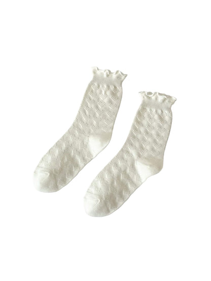 Side view of Rufia beige socks highlighting diamond knit design