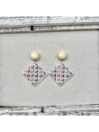 Earwish geometric diamond drop earrings laid flat with soft lighting