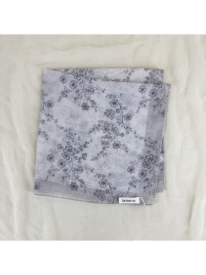 Edge detail of scarf showing fine stitching and soft fabric with blossom print