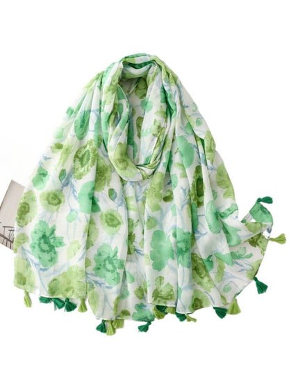 Model wearing Scarvii Watercolour Bloom Tassel Scarf draped around neck with floral print visible