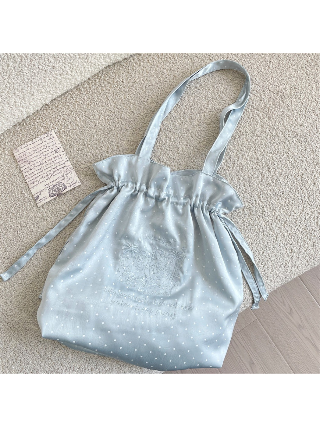Side view of Cosbai polka dot drawstring shoulder bag showing strap and shape