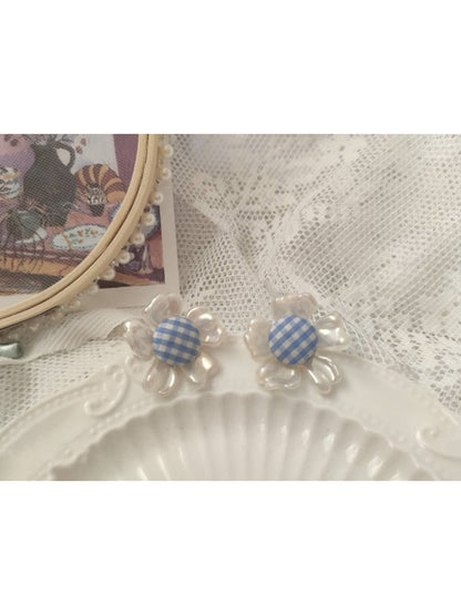 Earwish gingham flower stud earrings worn on a model's ear showing size and fit