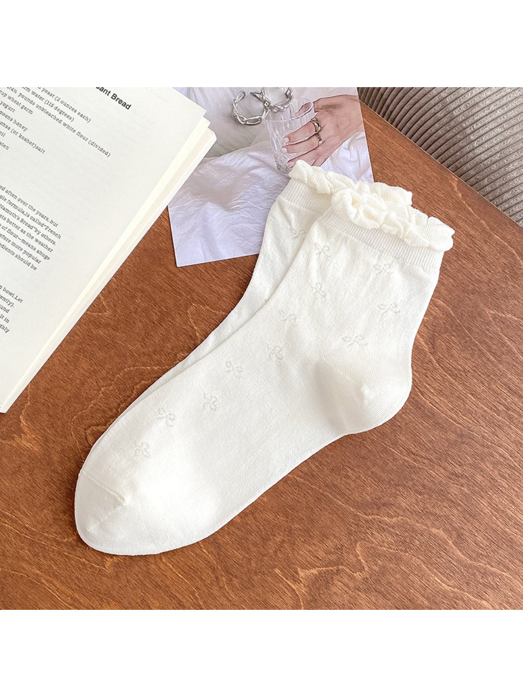 Flat lay of cream Rufia Sweet Bow Knit Crew Socks with bow on ankle