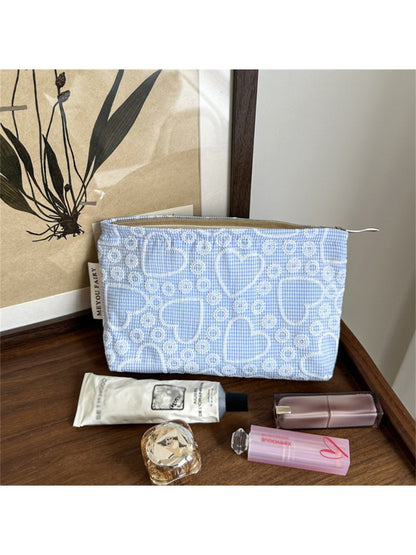 Cosbai makeup bag next to cosmetic items, illustrating size and usage