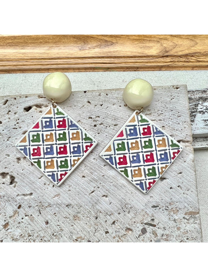 Model wearing Earwish geometric diamond drop earrings with a black top