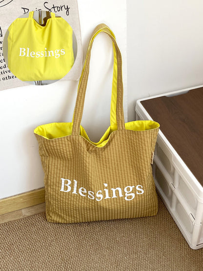 Model holding Cosbai reversible blessings graphic tote bag by handles