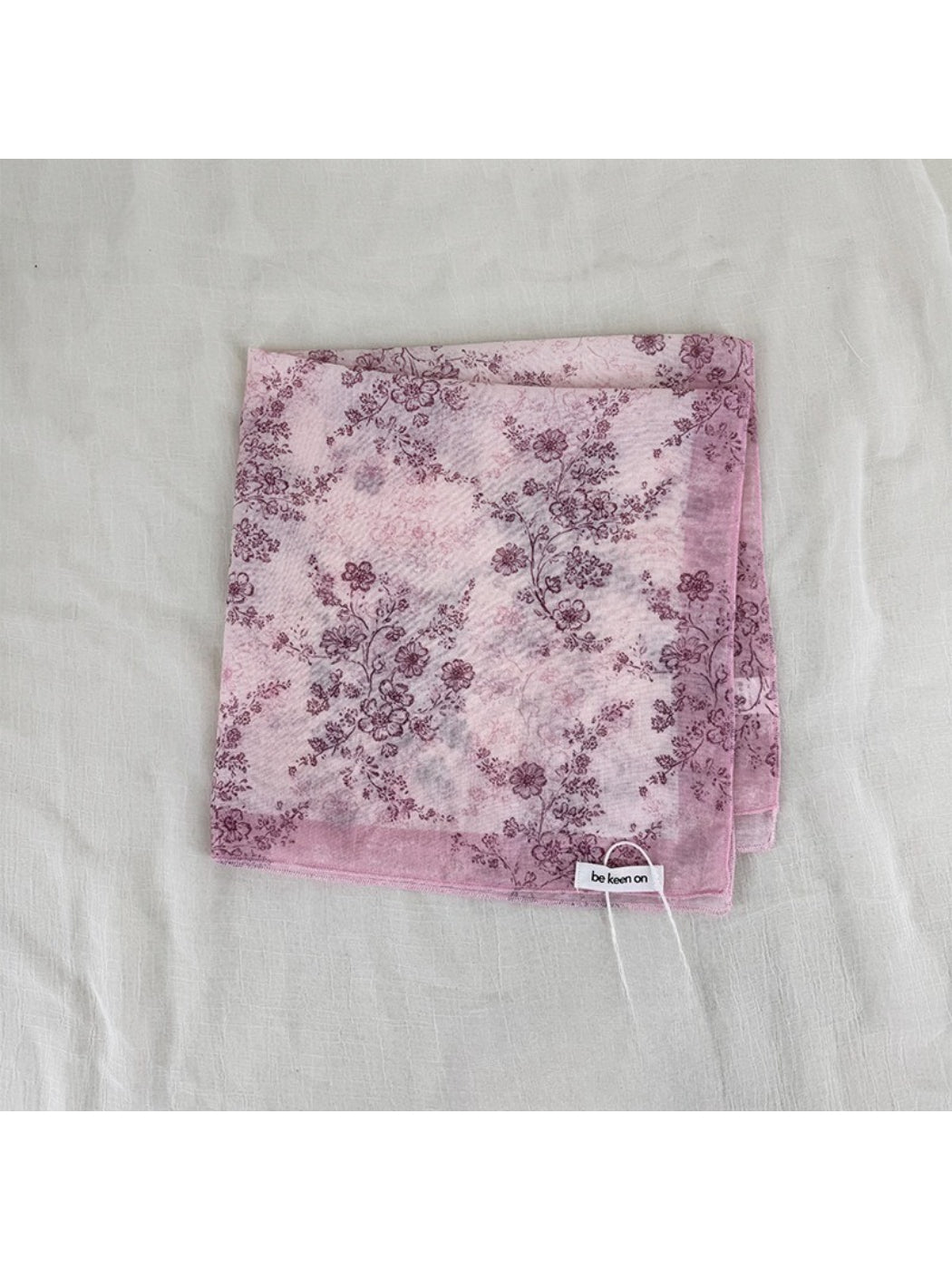 Scarf draped over a mannequin highlighting soft floral design and smooth texture
