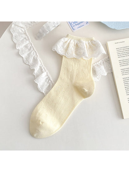 Rufia lace ruffle trim crew socks in white on a light fabric background