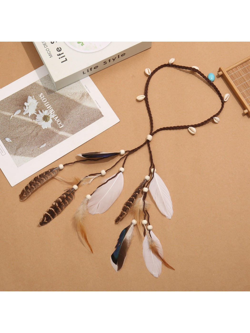 Side view of boho shell feather tassel hair headpiece highlighting feather and shell arrangement