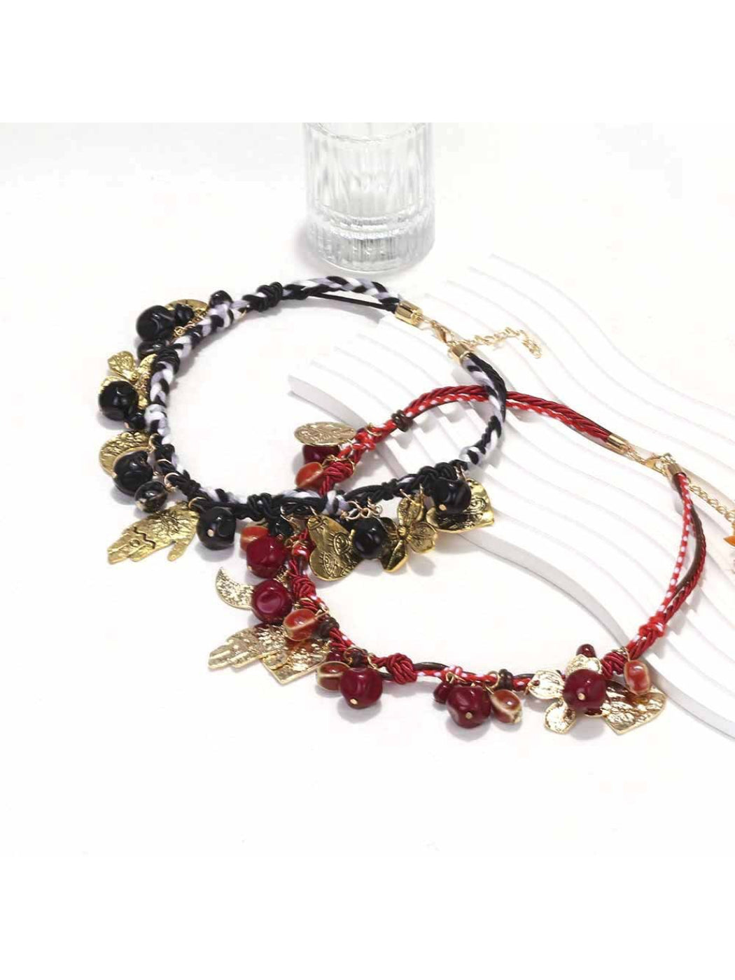 Close-up of Neckit beaded necklace with detailed floral charms on a neutral surface