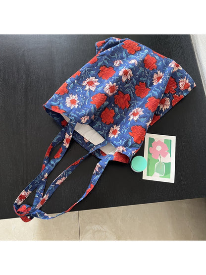 Blue floral shoulder tote bag displayed with matching accessories