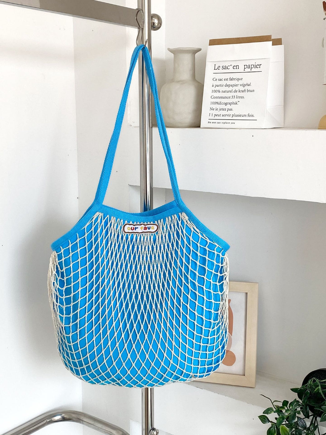 Cosbai tote bag hanging on a hook showing its lightweight and flexible design