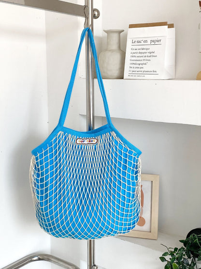 Cosbai tote bag hanging on a hook showing its lightweight and flexible design