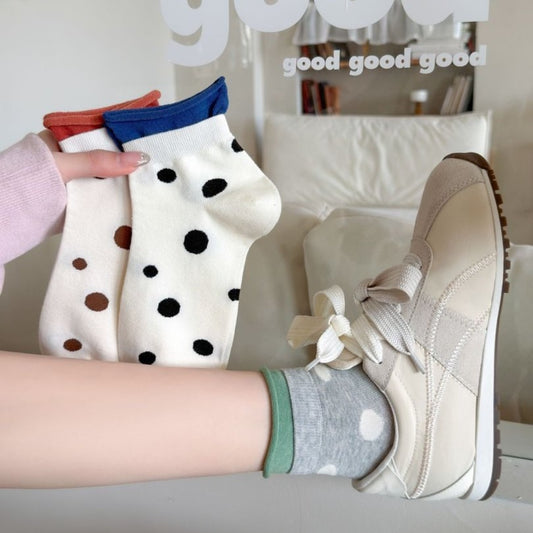 Pair of Rufia Soft Spot Pattern Crew Socks in beige with black spots laid flat