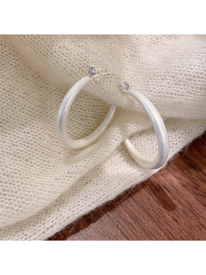Glossy color hoop earrings arranged in a circular pattern
