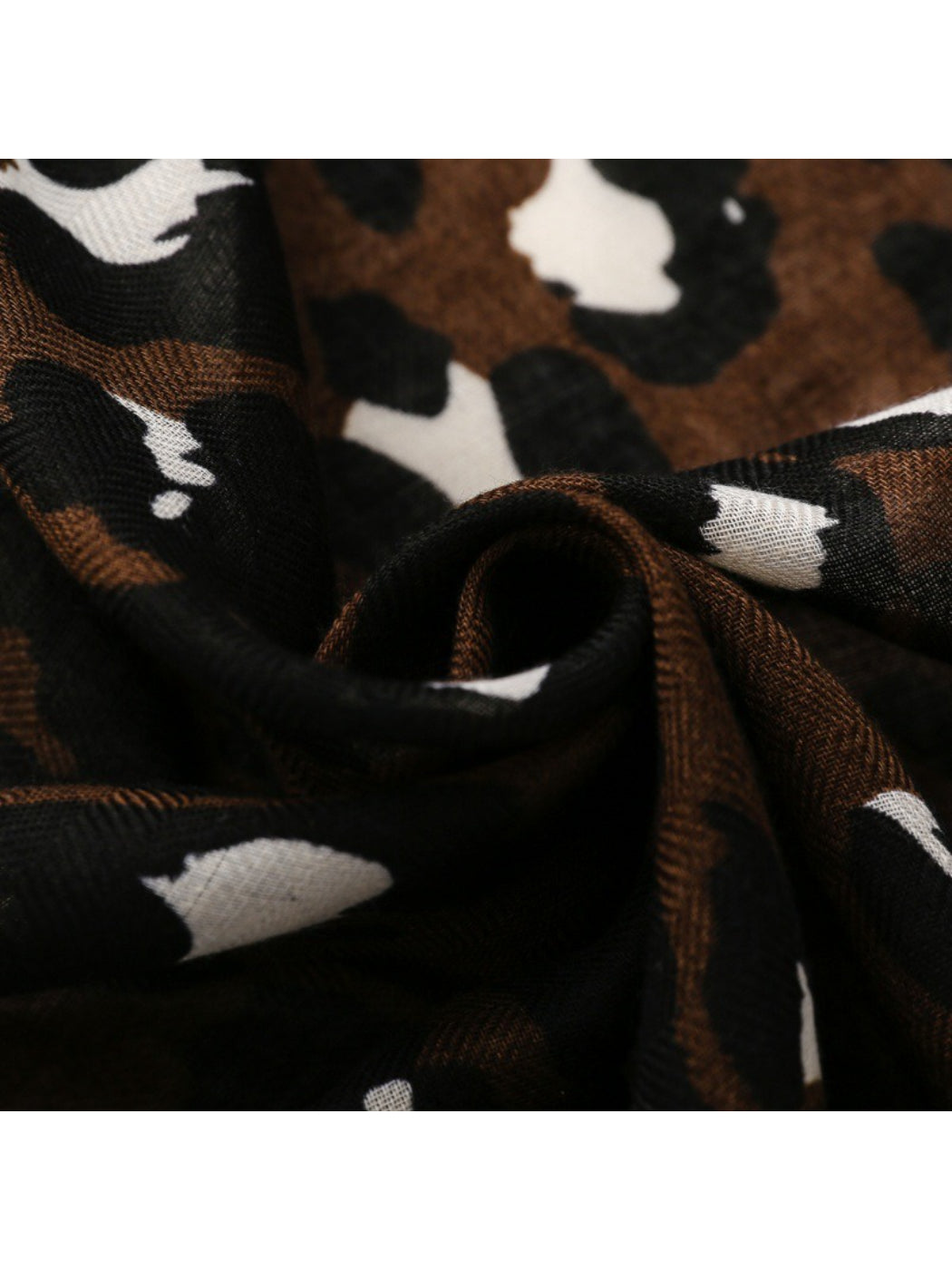 Brown leopard scarf wrapped around neck showing fringe detail