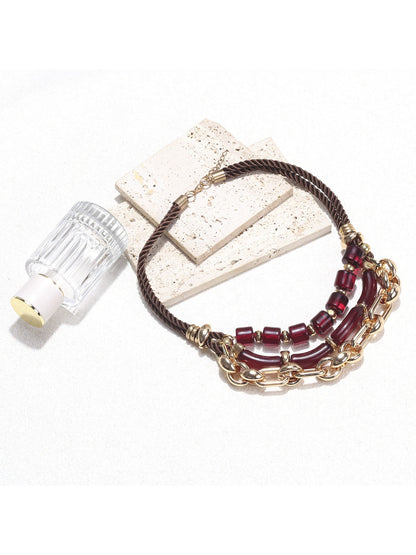 Neckit layered chain necklace with red beads displayed on a flat surface
