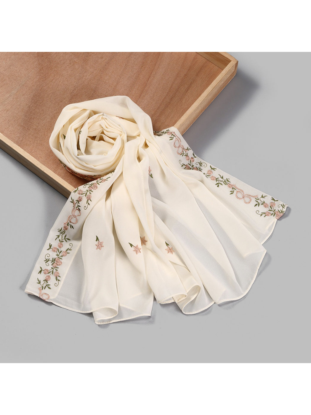 Scarf draped over a chair showcasing botanical embroidery