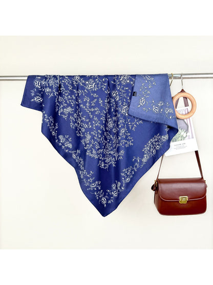 Scarvii bandana styled as a headband featuring green vine and floral motifs