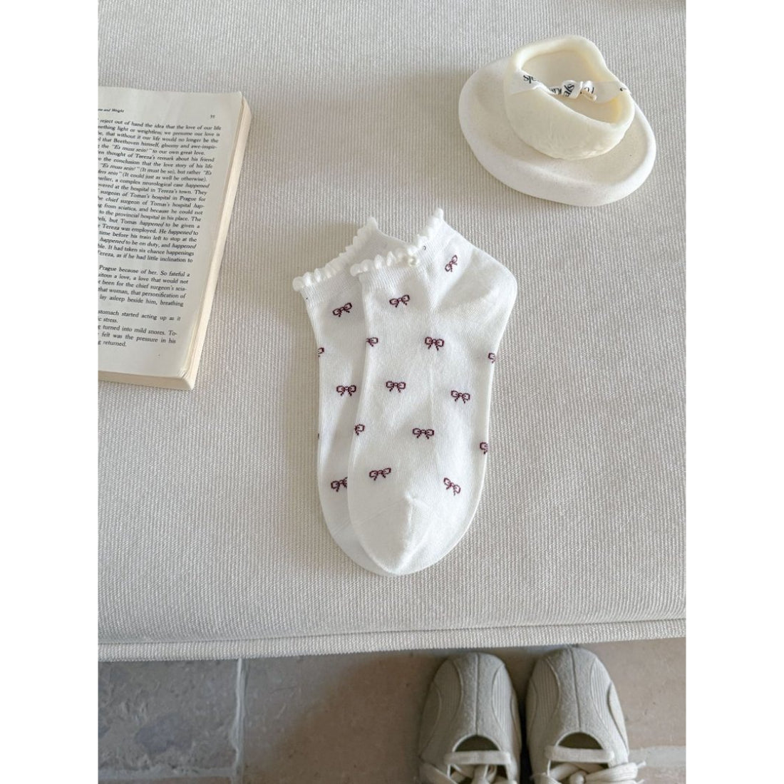 Rufia no show socks in pastel pink with bow motif, laid out flat