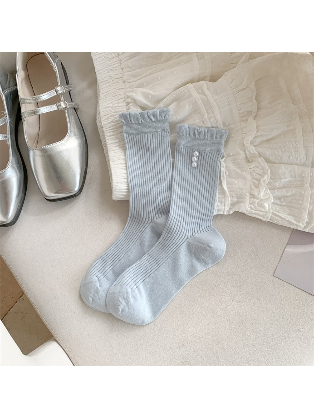Stack of Rufia soft rib crew socks in neutral tones with trim detail