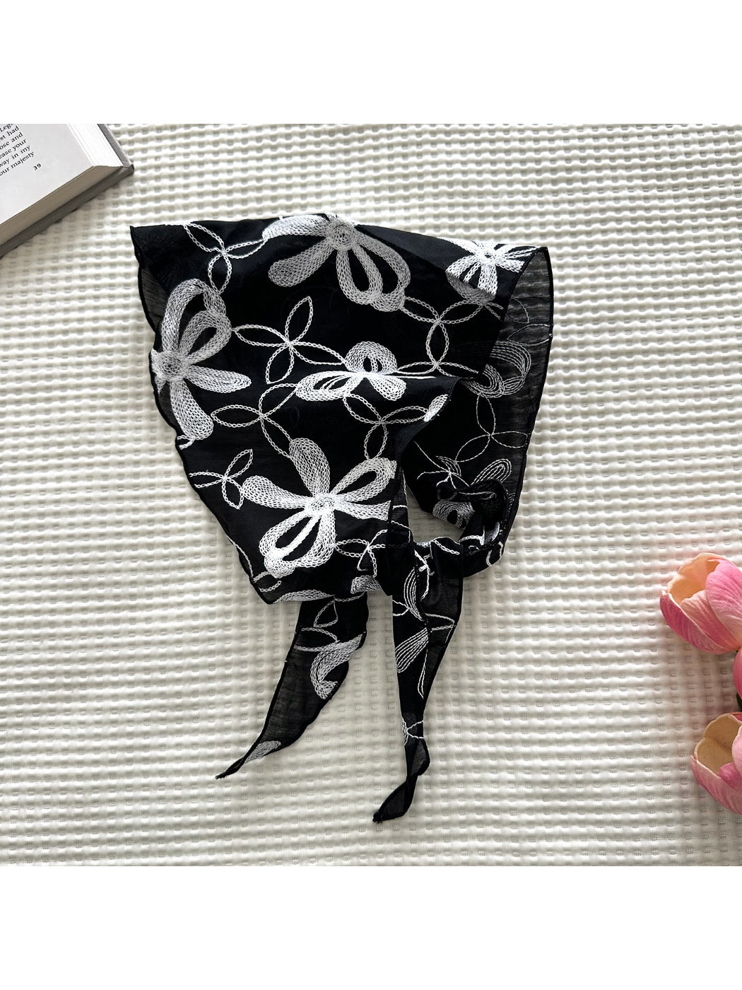 Close-up of embroidered floral pattern on sheer fabric of triangle scarf