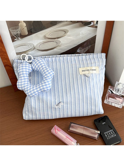 Striped cosmetic bag open displaying interior compartments