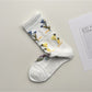 Pair of Rufia mesh floral mid-calf socks laid out to show full floral mesh pattern