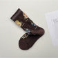 Side view of Rufia mesh floral mid-calf socks worn on feet with visible floral mesh design
