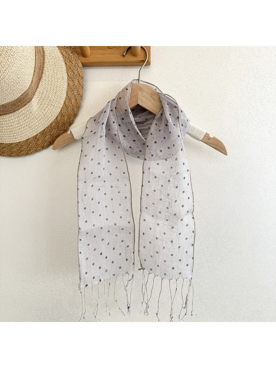 Model wearing Scarvii polka dot long skinny scarf styled around neck