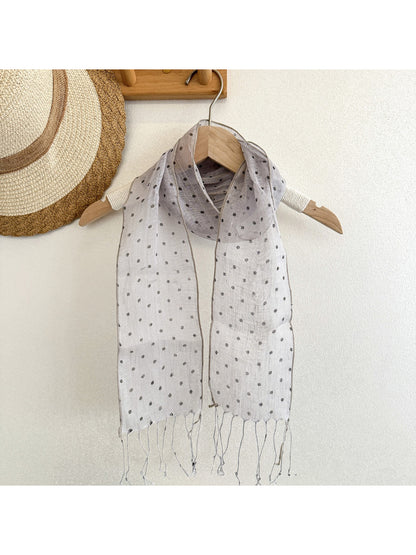 Model wearing Scarvii polka dot long skinny scarf styled around neck
