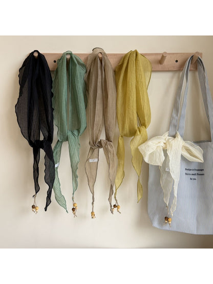 Soft draped triangle bandana scarf in light beige fabric displayed flat