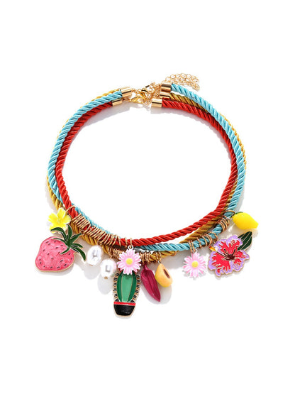 Neckit Summer Charm Necklace with mixed fruit and floral charms arranged on a flat surface