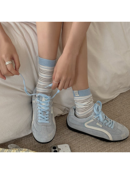 Pair of Rufia socks on wooden surface showing color contrast and stripes