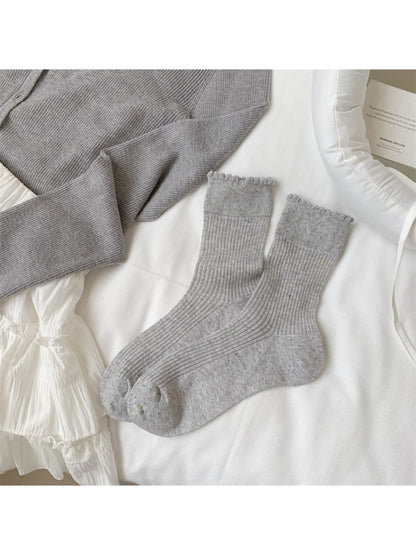 Pair of Rufia rib crew socks standing upright showing ribbed cuff and knit texture
