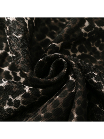 Close-up of the Black leopard-print scarf gathered into soft folds