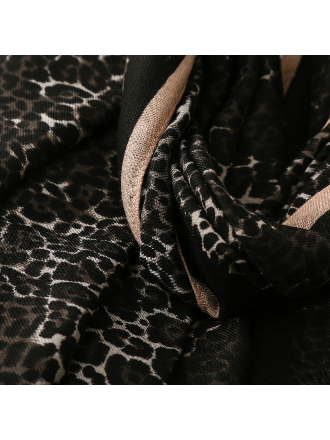 Close-up of the Black scarf's folded border and beige reverse side