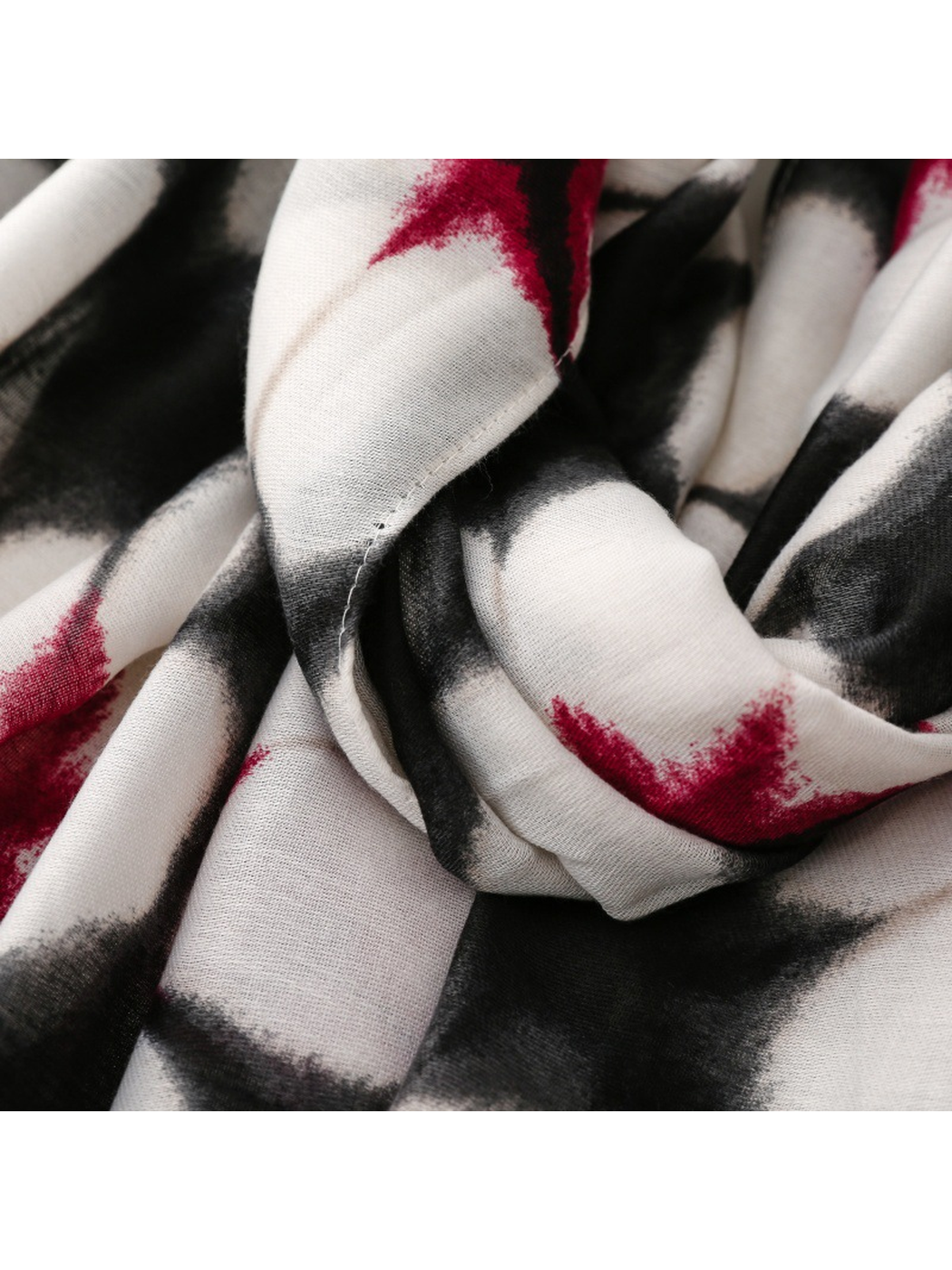 Close-up of Floral scarf red flower centers and black outlines across gathered folds