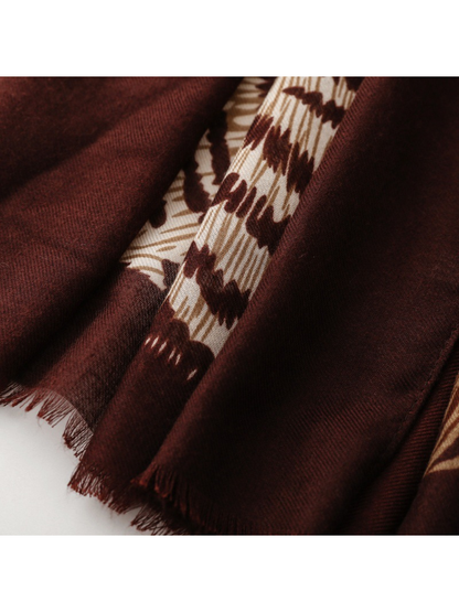 Close-up of Leopard scarf short burgundy fringe beside the cream motif