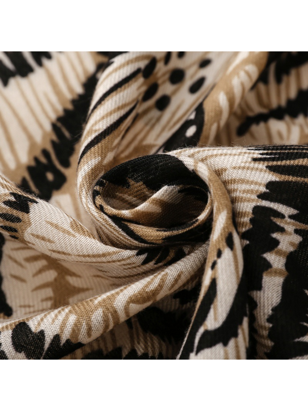 Close-up of Tiger scarf gathered black, cream and tan folds and fine texture