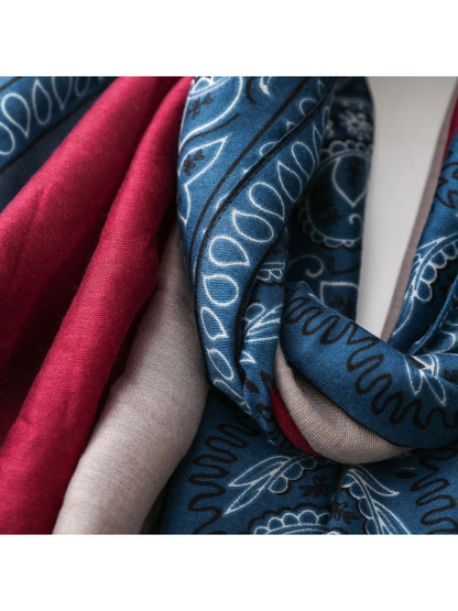Close-up of folded blue, red and light gray scarf panels and paisley print