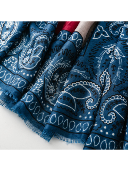 Close-up of blue fringe extending from the paisley-printed edge