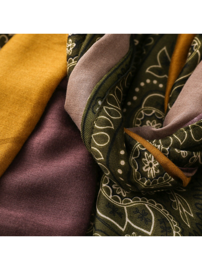 Close-up of mustard and mauve panels meeting the olive paisley border