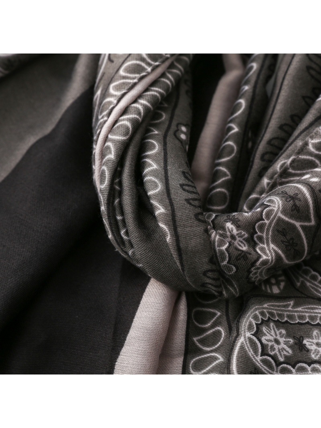 Close-up of folded black and gray paisley fabric with fine woven texture