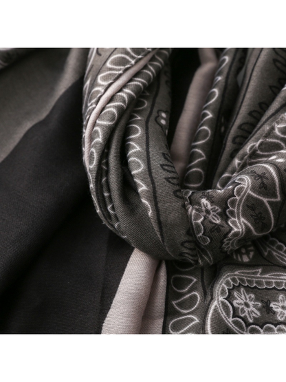Close-up of folded black and gray paisley fabric with fine woven texture