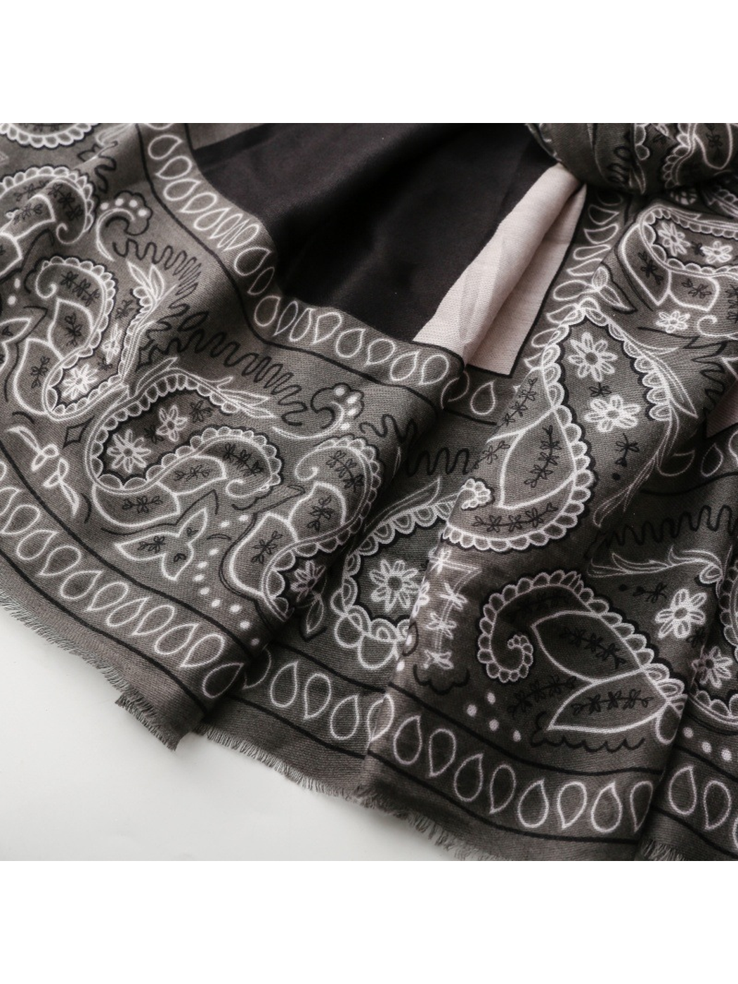 Close-up of short gray fringe beneath the black paisley border
